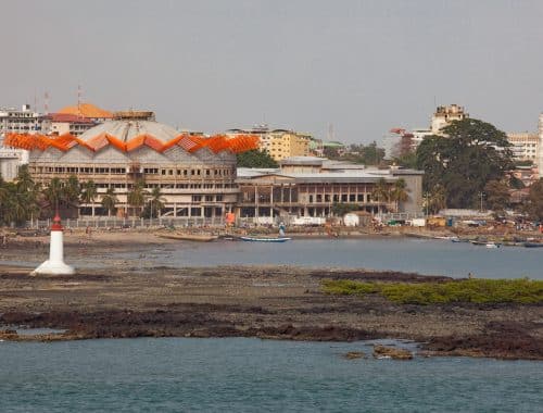 white and brown concrete building near body of water during daytime