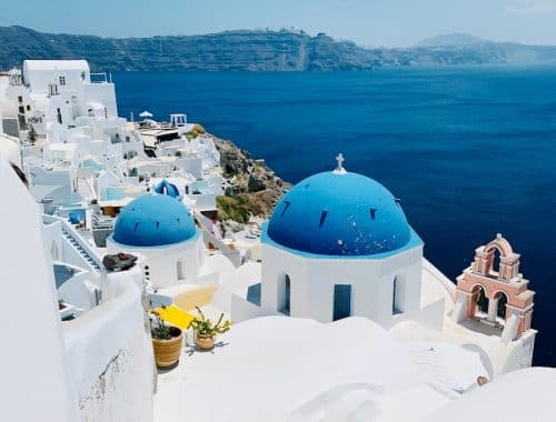 a view of a blue domed building on the edge of a cliff