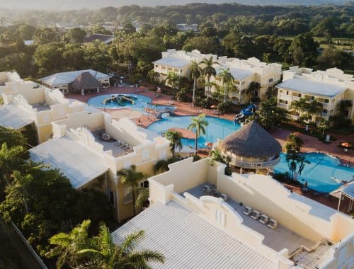 an aerial view of a resort surrounded by palm trees