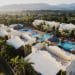 an aerial view of a resort surrounded by palm trees